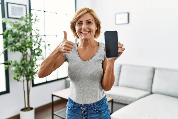 Medelålders Blond Kvinna Som Arbetar Håller Smartphone Visar Skärmen Ler — Stockfoto