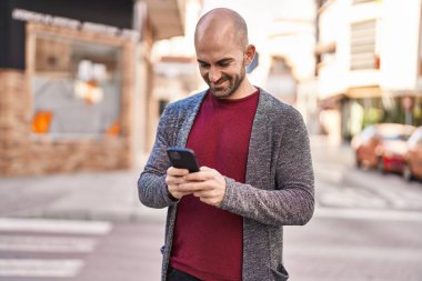 Sokakta akıllı telefon kullanan kendine güvenen genç adam.