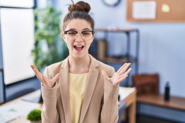 Ofiste çalışan genç kız gözlükleriyle başarıyı kutluyor. Kollarını kaldırmış, gözlerini kapatmış heyecanla haykırıyor. Kazanan konsept 