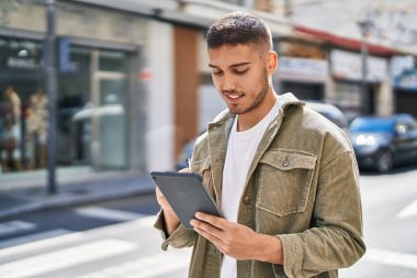 Sokakta dokunmatik ped kullanan, kendine güvenen İspanyol genç adam.