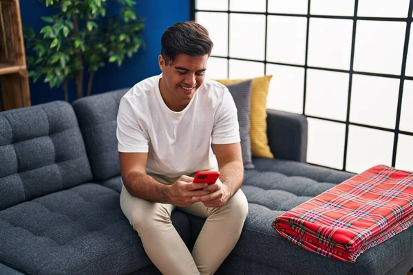 Junger Hispanischer Mann Sitzt Mit Smartphone Hause Auf Sofa — Stockfoto