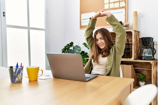 年轻的惊慌失措的女人带着自信的笑容在办公室里张开双臂 — 图库照片