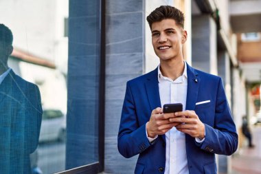 Sokakta akıllı telefon kullanan genç bir adam.