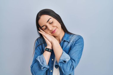 Mavi arka planda dikilen İspanyol kadın uyuyordu. Yorgun düşler görüyordu ve elleriyle poz veriyordu. Gözleri kapalıyken gülümsüyordu.. 