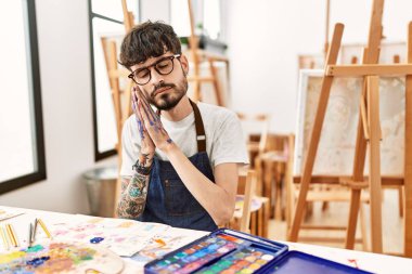 Resim stüdyosunda sakallı İspanyol bir adam uyuyordu. Yorgun düşler görüyordu ve elleriyle poz veriyordu. Gözleri kapalıyken gülümsüyordu.. 