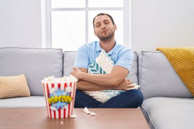 İspanyol adam evde televizyon seyrediyor. Kanepede oturup kameraya bakıyor. Öpüşme sahnesini çekiyor. aşk ifadesi. 