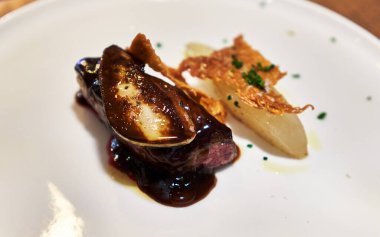  Ördek eti, kaz ciğeri ve ahşap yüzeyde armut.