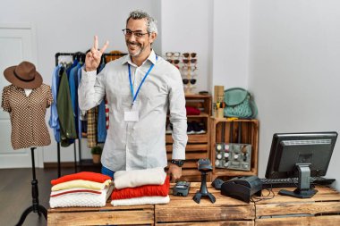 Orta yaşlı İspanyol bir adam perakende mağazasında müdür olarak çalışıyor kameraya bakıp zafer işareti yaparken gülümsüyor. İki numara.. 