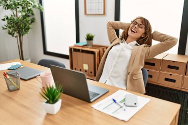 Kafkasyalı genç iş kadını, elleri ofiste çalışırken rahat..