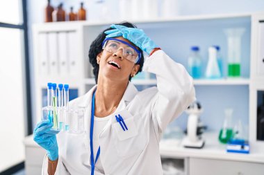 Orta yaşlı İspanyol kadın laboratuvarda çalışıyor. Kafası karışık, şaşırmış ve kızgın yüzüyle stresli ve sinirli. 