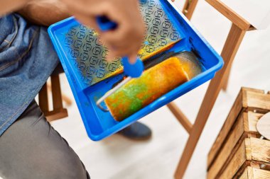 Resim stüdyosunda boya silindiri kullanan Afrikalı Amerikalı bir sanatçının eli..