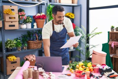 Çiçekçide dizüstü bilgisayar kağıdı kullanan İspanyol bir çiçekçi.