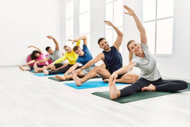 Spor merkezinde mutlu bir yoga eğitimi veren bir grup genç..