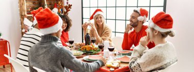 Bir grup genç arkadaş yılbaşı yemeğini evde masada yiyorlar..