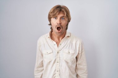 Orta yaşlı bir adam şok suratlı, ağzı açık kalmış, şüpheci ve alaycı bir görünüm sergiliyor. 