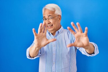 İspanyol kıdemli gözlüklü, korkudan dehşete düşmüş ve korkmuş bir adam. El hareketini durdur, şok içinde bağır. panik konsepti. 