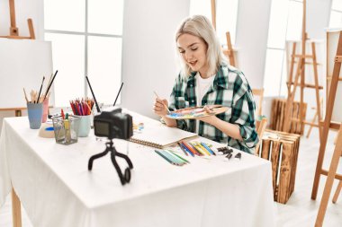 Genç ressam kız mutlu resim çiziyor. Sanat atölyesindeki masa başı resim dersinde otururken..