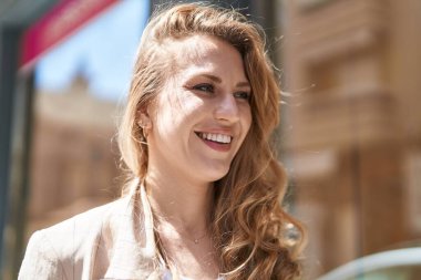Young blonde woman smiling confident looking to the side at park