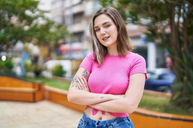 Young woman smiling confident standing with arms crossed gesture at park