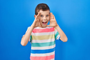 Mavi arka planda dikilen beyaz bir çocuk gülümseyen, güler yüzlü bir şekilde yüzünü gösteren bir böceğe bakıyor. Şaşırdım ve çıktım. 