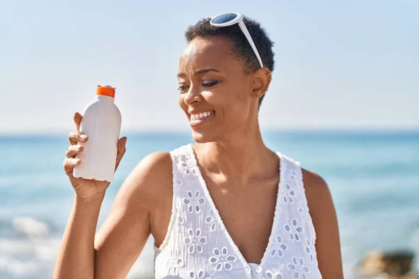 Afrikansk Amerikansk Kvinna Ler Säker Hålla Solskyddsmedel Flaska Vid Havet — Stockfoto