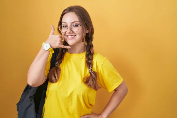 Mladá Běloška Oblečená Studentském Batohu Přes Žluté Pozadí Usmívá Gestikuluje — Stock fotografie