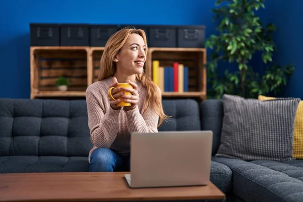 Ung Kvinna Som Använder Laptop Och Dricker Kaffe Sittandes Soffan — Stockfoto