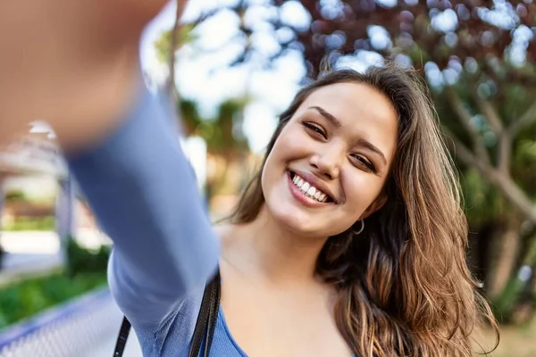 Mutlu gülümseyen genç İspanyol kız şehrin kamerasının önünde selfie çekiyor..