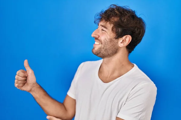 Hispanic Ung Man Står Över Blå Bakgrund Ser Stolt Leende — Stockfoto