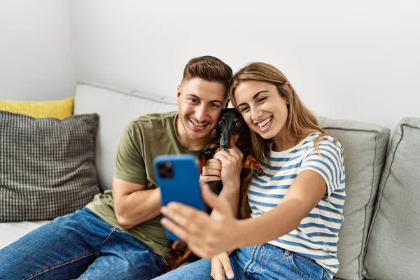 Young Hispanic Couple Make Selfie Smartphone Sitting Sofa Dog Home — Fotografia de Stock