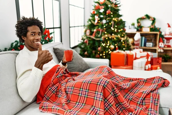 Joven Afroamericano Sentado Sofá Bebiendo Café Junto Árbol Navidad Haciendo — Foto de Stock