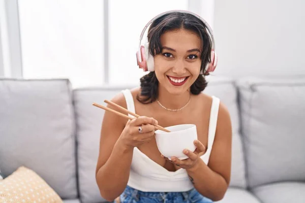 年轻的惊慌失措的女人吃着亚洲菜 用筷子笑着 脸上带着快乐而凉爽的笑容 显示牙齿 — 图库照片