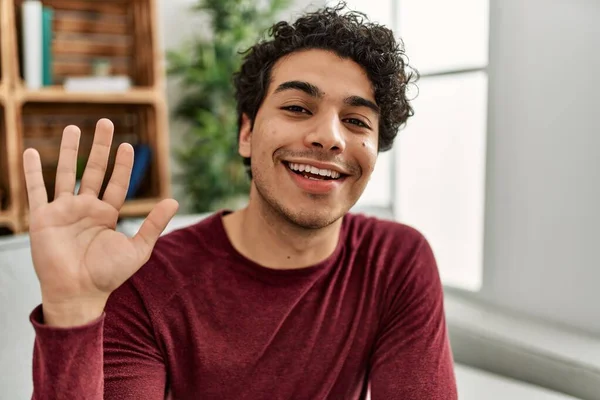 Ung Latinamerikansk Man Ler Glad Säga Hej Med Handen Hemma — Stockfoto