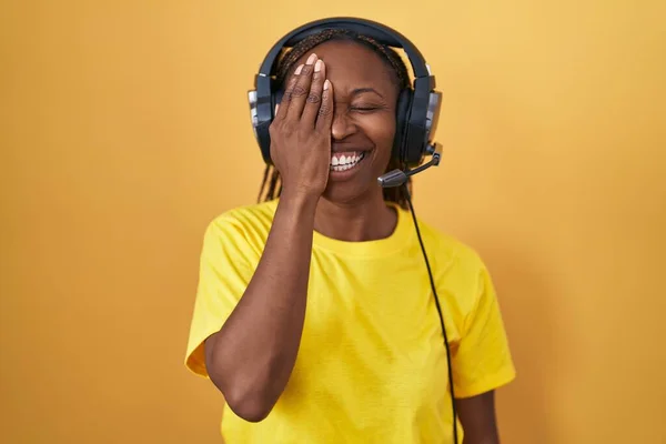 Mujer Afroamericana Escuchando Música Usando Auriculares Cubriendo Ojo Con Mano —  Fotos de Stock