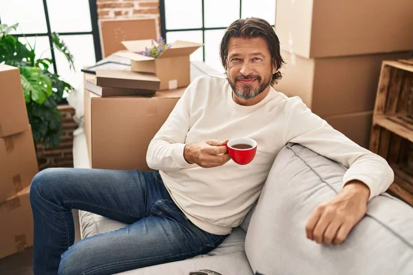 Hombre Mediana Edad Bebiendo Café Sentado Sofá Nuevo Hogar —  Fotos de Stock
