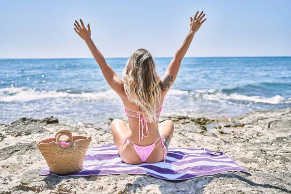 Young Blonde Girl Back View Sitting Towel Hands Raised Beach — Stock fotografie