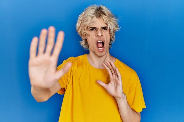 Jeune Homme Moderne Debout Sur Fond Bleu Effrayé Terrifié Par — Photo