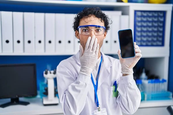 Hispánec Pracující Laboratoři Vědců Ukazující Obrazovce Smartphonu Ústa Šokovaný Vystrašený — Stock fotografie
