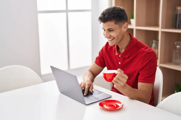 Joven Hispano Usando Laptop Bebiendo Café Sentado Mesa Casa —  Fotos de Stock