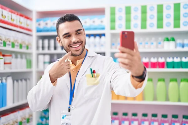 Joven Hispano Trabajando Farmacia Haciendo Videollamada Con Smartphone Sonriendo Feliz —  Fotos de Stock