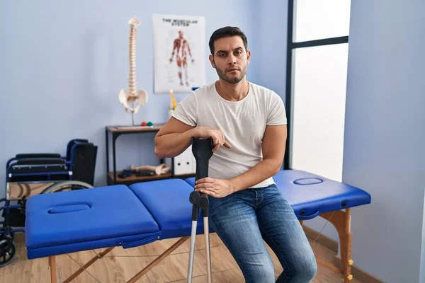 Joven Hombre Hispano Con Barba Llevando Muletas Clínica Rehabilitación Pensando — Foto de Stock