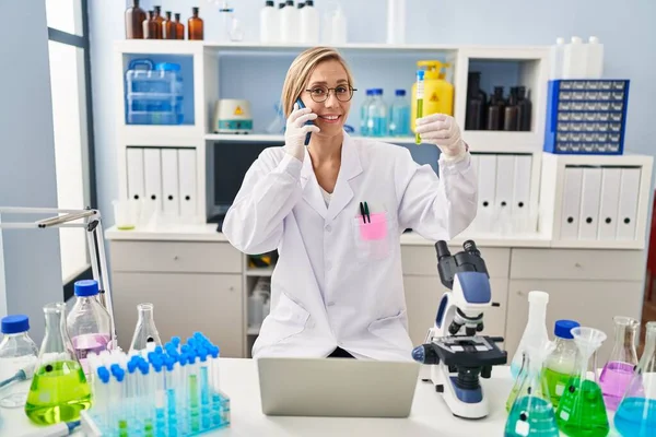 Young Blonde Woman Scientist Talking Smartphone Holding Test Tube Laboratory — Stock Photo, Image