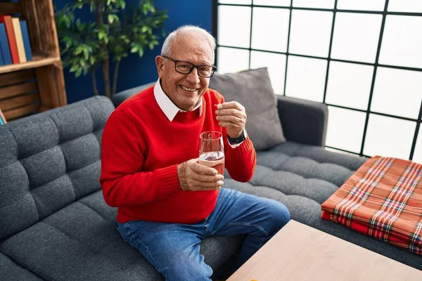 Senior Muž Usměvavý Sebevědomě Brát Pilulky Doma — Stock fotografie