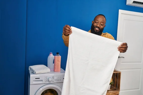 Genç Afrikalı Amerikalı Gülümseyen Adam Çamaşır Odasında Havluyu Tutarken Kendine — Stok fotoğraf