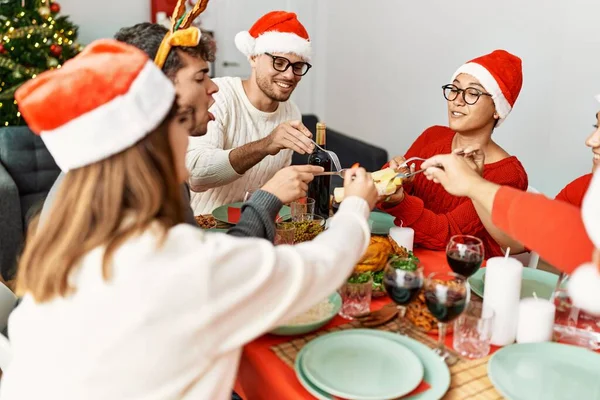 Ομάδα Νέων Ανθρώπων Χαμογελώντας Ευτυχισμένοι Έχοντας Χριστουγεννιάτικο Δείπνο Στο Σπίτι — Φωτογραφία Αρχείου
