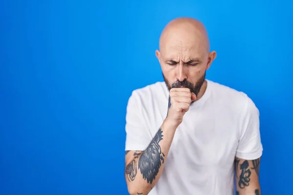 有纹身的西班牙男人站在蓝色背景上感觉不适 咳嗽是感冒或支气管炎的症状 保健概念 — 图库照片