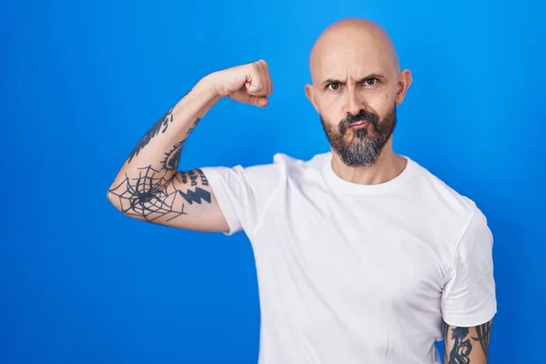 Латиноамериканец Татуировками Стоящий Синем Фоне Сильный Человек Показывающий Мышцы Рук — стоковое фото