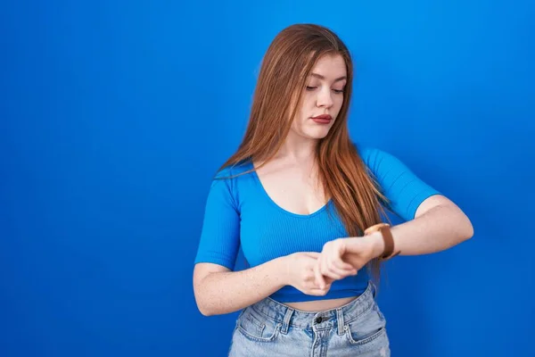 Mujer Pelirroja Pie Sobre Fondo Azul Comprobando Hora Reloj Pulsera —  Fotos de Stock