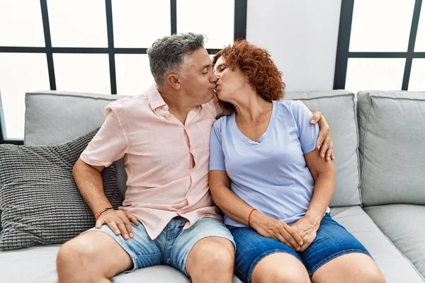 中年男性と女性カップル巨大お互いと接吻上のソファにホーム — ストック写真