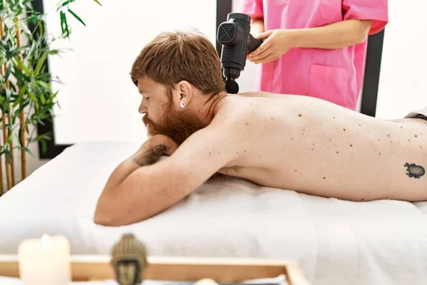 Young Redhead Man Having Back Massage Using Percussion Pistol Beauty — Stockfoto